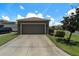 Spacious two-car garage with a concrete driveway and manicured landscaping at 2706 Lantern Hill Ave, Brandon, FL 33511