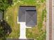 Aerial view of home showing new roof, driveway, and proximity to train tracks on an overgrown lot at 301 S Daniels St, Plant City, FL 33563