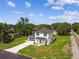 Aerial view displays beautiful two-story home with a well-manicured lawn and lush green surroundings near train tracks at 301 S Daniels St, Plant City, FL 33563
