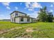 Large backyard showcasing the covered patio, modern exterior, and sizable green lawn at 301 S Daniels St, Plant City, FL 33563