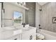 Bathroom features a white vanity with a quartz countertop and modern fixtures and gray tiled shower at 301 S Daniels St, Plant City, FL 33563
