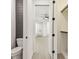 Bathroom and closet hallway showcases gray wood paneled accent wall and neutral paint at 301 S Daniels St, Plant City, FL 33563