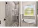 Modern bathroom with glass shower and a soaking tub, plus a framed window at 301 S Daniels St, Plant City, FL 33563