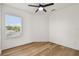 Bright bedroom with hardwood floors, large window with blinds and a ceiling fan at 301 S Daniels St, Plant City, FL 33563