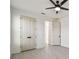 Bedroom with tiled floor features a ceiling fan, and double doors with dark hardware at 301 S Daniels St, Plant City, FL 33563