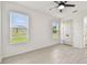 Bright bedroom features tile flooring, a ceiling fan, and windows offering plenty of natural light at 301 S Daniels St, Plant City, FL 33563