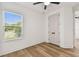 Bright bedroom features wood-look floors, a window with blinds, and a ceiling fan at 301 S Daniels St, Plant City, FL 33563