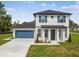 Charming two-story home with blue shutters, a well-manicured lawn and a two car garage at 301 S Daniels St, Plant City, FL 33563