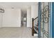 Inviting foyer with light gray tile flooring, leading to a staircase and open living spaces at 301 S Daniels St, Plant City, FL 33563