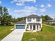 Beautiful two-story home featuring a blue garage door, nice lawn, and welcoming entryway near train tracks at 301 S Daniels St, Plant City, FL 33563