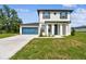 Charming two-story home featuring a blue garage door, nice lawn, and a welcoming entryway at 301 S Daniels St, Plant City, FL 33563