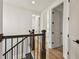 Bright hallway featuring wood floors, a dark wood banister, and white walls, doors and trim throughout at 301 S Daniels St, Plant City, FL 33563