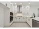 Modern, remodeled kitchen featuring white cabinets, stainless appliances, quartz counters, and gray wood-look tile at 301 S Daniels St, Plant City, FL 33563