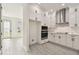 Bright, remodeled kitchen featuring modern stainless steel appliances, white cabinets, and gray wood-look tile flooring at 301 S Daniels St, Plant City, FL 33563
