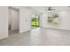 Spacious living room with gray wood-look tile flooring, recessed lighting, and a sliding glass door to the backyard at 301 S Daniels St, Plant City, FL 33563