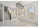 Bright living room featuring sleek tile flooring, a modern light fixture, and staircase to the second floor at 301 S Daniels St, Plant City, FL 33563
