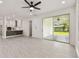 Open-concept living area with a renovated kitchen, gray wood-look flooring, and a sliding glass door to the patio at 301 S Daniels St, Plant City, FL 33563