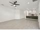 Open-concept living room with a ceiling fan, tile floors, and a view of the modern kitchen at 301 S Daniels St, Plant City, FL 33563
