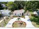 Aerial view of a landscaped single-story home featuring a circular driveway, mature trees, and well-maintained lawn at 3115 Bay Ln, Clearwater, FL 33759