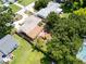 Overhead view of a single-story home with a circular driveway, mature trees, and a well-kept lawn at 3115 Bay Ln, Clearwater, FL 33759