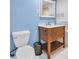 Bathroom features blue accent wall, wooden vanity, and modern white tile shower at 3115 Bay Ln, Clearwater, FL 33759