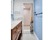 Modern bathroom with glass shower, blue accent wall, and wooden vanity at 3115 Bay Ln, Clearwater, FL 33759