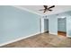 Spacious bedroom with tile floors, ceiling fan, blue walls, and convenient closet access at 3115 Bay Ln, Clearwater, FL 33759