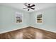 Bright bedroom featuring hardwood floors, a ceiling fan, and dual windows allowing natural light at 3115 Bay Ln, Clearwater, FL 33759