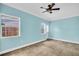 Bedroom with light blue walls, tile floors, ceiling fan, and windows for plenty of natural light at 3115 Bay Ln, Clearwater, FL 33759