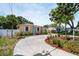 Quaint single-story home featuring a well-maintained lawn, circular driveway, and bright blue front door at 3115 Bay Ln, Clearwater, FL 33759