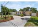 Inviting single-story home with a circular driveway, lush landscaping, and a welcoming bright blue front door at 3115 Bay Ln, Clearwater, FL 33759