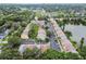 Aerial view showcasing colorful townhomes nestled among trees with a serene lake nearby at 3308 W Wyoming Cir, Tampa, FL 33611