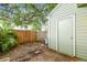 Small backyard with a wooden fence, greenery, and access to the house and a shed at 3308 W Wyoming Cir, Tampa, FL 33611