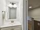 Bathroom with a sink, mirror, and towel bar, with view to the kitchen at 3308 W Wyoming Cir, Tampa, FL 33611