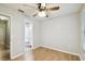 Bedroom with light wood flooring, ceiling fan, and a door leading to the bathroom at 3308 W Wyoming Cir, Tampa, FL 33611