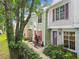 Attractive townhouses with colorful facades and unique doors, framed by lush landscaping and mature trees at 3308 W Wyoming Cir, Tampa, FL 33611