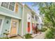 Townhouse exterior featuring vibrant colors and a welcoming entrance with colorful doors, shutters, and landscaping at 3308 W Wyoming Cir, Tampa, FL 33611