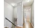 Upstairs hallway area, with view to the living room, features neutral walls and flooring at 3308 W Wyoming Cir, Tampa, FL 33611