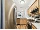 Updated kitchen boasts stainless steel appliances, wood cabinets, and views to the living room at 3308 W Wyoming Cir, Tampa, FL 33611