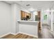 Open kitchen featuring wood cabinets and stone countertops with a view to the entryway at 3308 W Wyoming Cir, Tampa, FL 33611