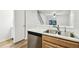 Kitchen with stainless steel dishwasher and a sink overlooking the living area and stairs at 3308 W Wyoming Cir, Tampa, FL 33611