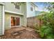Back patio area with a sliding glass door, leading into the home and a wooden fence at 3308 W Wyoming Cir, Tampa, FL 33611