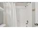 The bath includes a shower with a shower curtain and neutral paint at 3308 W Wyoming Cir, Tampa, FL 33611