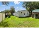 Rear exterior view showing fenced yard, well-kept lawn, and storage shed at 4537 Thornton Dr, Zephyrhills, FL 33542
