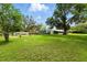 Expansive backyard featuring lush green grass and mature trees offering ample outdoor space at 4537 Thornton Dr, Zephyrhills, FL 33542