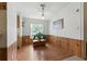 Bright dining area with wood paneling, laminate flooring, light fixture, and view of the backyard at 4537 Thornton Dr, Zephyrhills, FL 33542