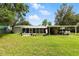 Well-maintained home with screened porch, lush front lawn, covered parking and shed at 4537 Thornton Dr, Zephyrhills, FL 33542