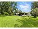 Expansive front yard showcases the home's exterior, covered parking, screened porch and shed at 4537 Thornton Dr, Zephyrhills, FL 33542