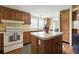 Traditional kitchen with wooden cabinets, island, white appliances, and window bringing in natural light at 4537 Thornton Dr, Zephyrhills, FL 33542