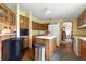 Functional kitchen with wood cabinets, white appliances, and center island providing a practical cooking space at 4537 Thornton Dr, Zephyrhills, FL 33542